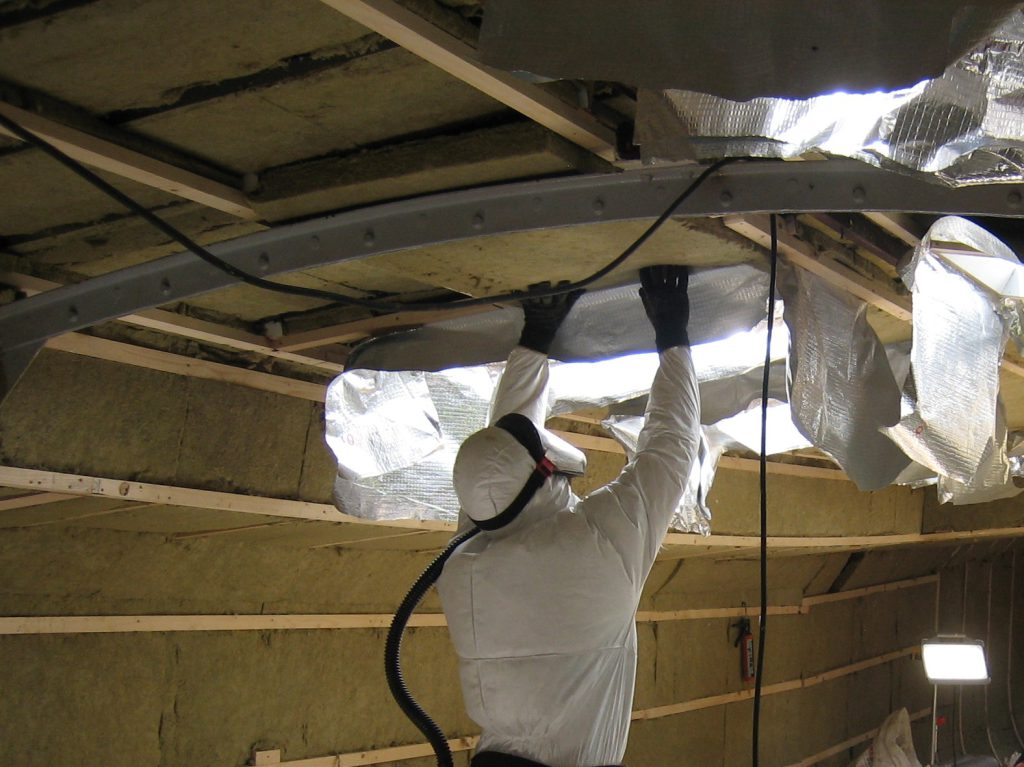 Scheepstimmerman isoleert plafond woonschip met twee lagen steenwol